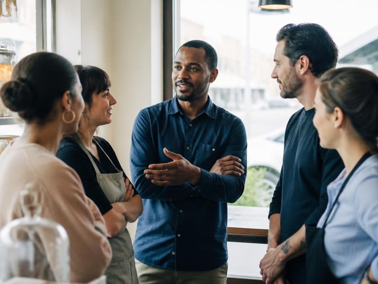 Small business team talking together in a bright storefront